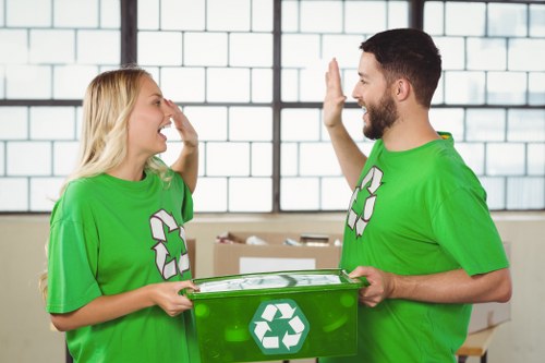 Workers sorting commercial recycling into separate containers at a depot